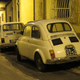 A FIAT 126 and FIAT 500 in Italy. The 126 has a much more modern and boxy shape for the time, but you can see the resemblance in their underpinnings if you look hard enough! Old meets new...